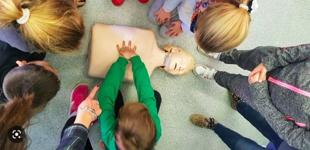 Grupo de niños practicando primeros auxilios y reanimación cardiopulmonar