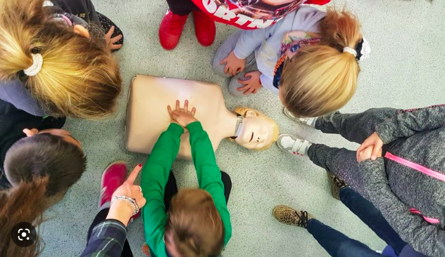 Grupo de niños practicando primeros auxilios y reanimación cardiopulmonar